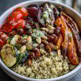 Vibrant veggie and quinoa power bowl with roasted vegetables, beans, and crunchy nuts, drizzled with lemon vinaigrette.