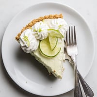 Freshly baked Key Lime Pie with a golden graham cracker crust, creamy citrus filling, and a fluffy whipped cream topping.