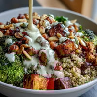 Overhead view of a vibrant Meal Prep Week-Long Power Bowl featuring roasted sweet potatoes, chickpeas, and a rich tahini dressing drizzled over fresh greens.