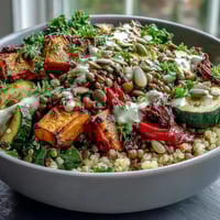 Savory Lentil Power Bowl with fluffy quinoa and vibrant roasted vegetables, drizzled in creamy tahini dressing for a wholesome, satisfying meal.